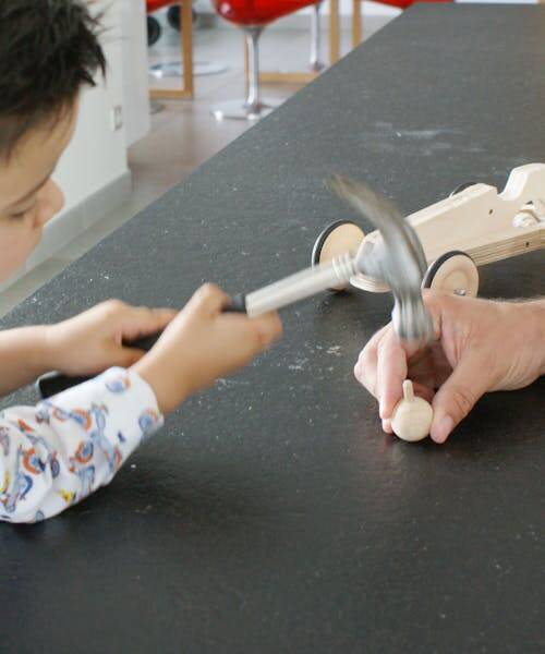 Enfant construisant une toupie et une voiture en bois et fabriqué en France.