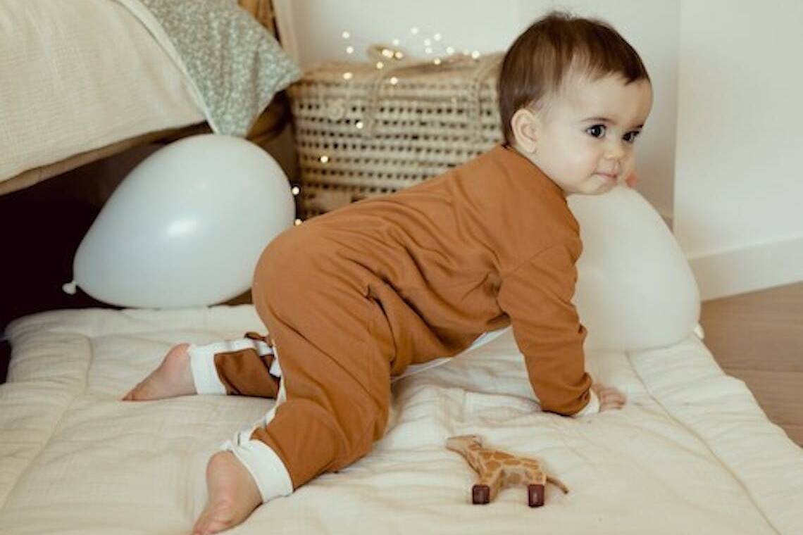 Bébé portant un pyjama marron fabriqué en France de la marque Manufacture des bébés français.