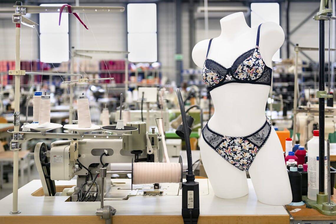 Photo de la manufacture de lingerie française de Lingerie indiscrète avec mannequin portant un ensemble de lingerie noire à fleurs.