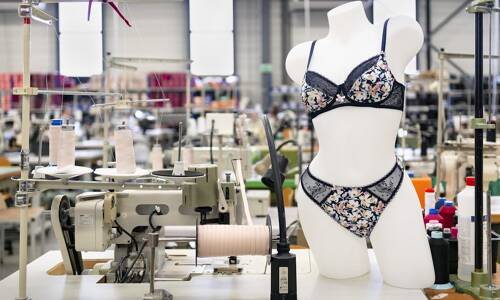 Photo de la manufacture de lingerie française de Lingerie indiscrète avec mannequin portant un ensemble de lingerie noire à fleurs.