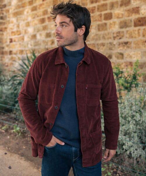 Homme brun portant une veste velours de couleur bordeaux fabriquée en France par Montlimart.