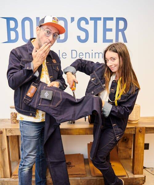 Homme et femme entrain de découper un jean Bolid'ster fabriqué en France.