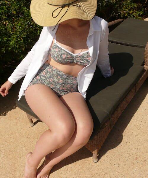 Femme portant un ensemble soutien-gorge culotte en imprimé vert fleuri.