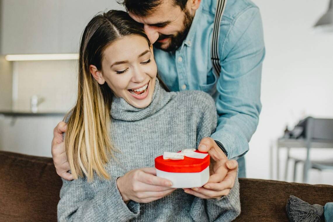 Homme offrant à son épouse un cadeau fabriqué en France dans une boite en forme de cœur pour la Saint-Valentin.