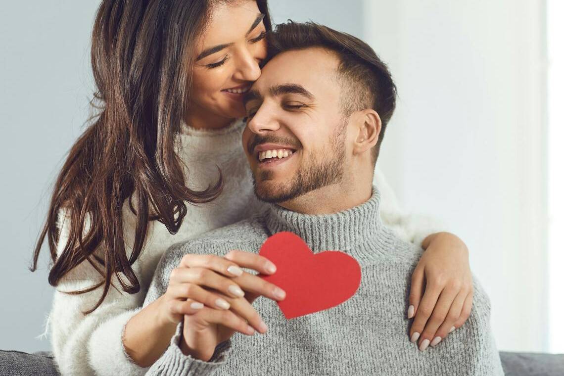 Femme offrant à son amoureux un cadeau Made in France et une carte en forme ce cœur pour la Saint-Valentin.