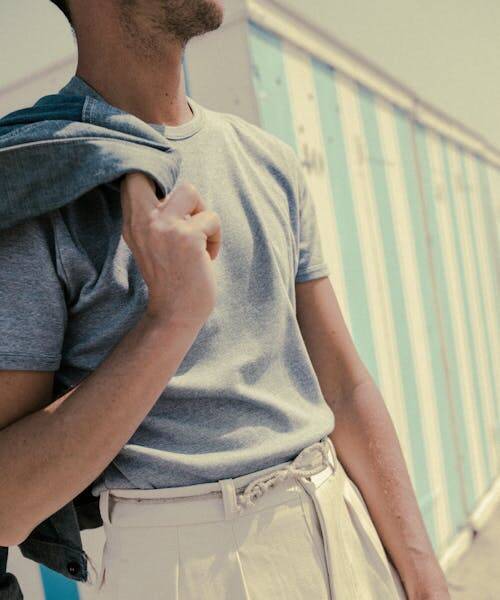 Homme portant un t-shirt en maille Made in France et un pantalon blanc.