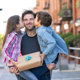 Papa recevant un bisous et un cadeau Made in France de la part de ses enfants.