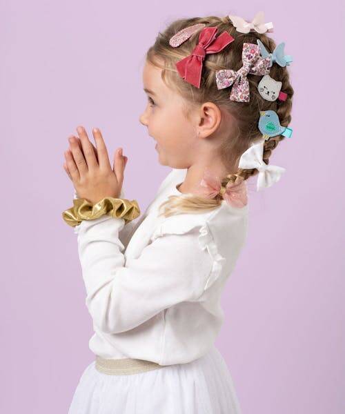 Jeune fille portant des barrettes fabriquées en France anti glisses de toute les couleurs : bleu, blanc, rouge, liberty, etc.