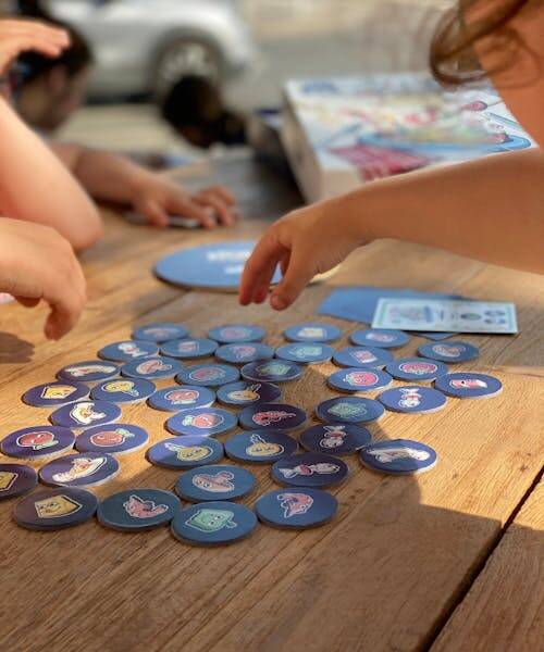 Deux enfants entrain de jouer au jeu de société Bolo ou Carbo édité par Luzocréa. Un jeu drôle et de rapidité Made in France.