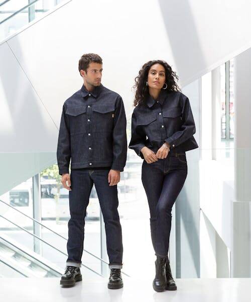 Homme et et femme portant un ensemble veste et pantalon en jean fabriqués en France à Nancy.