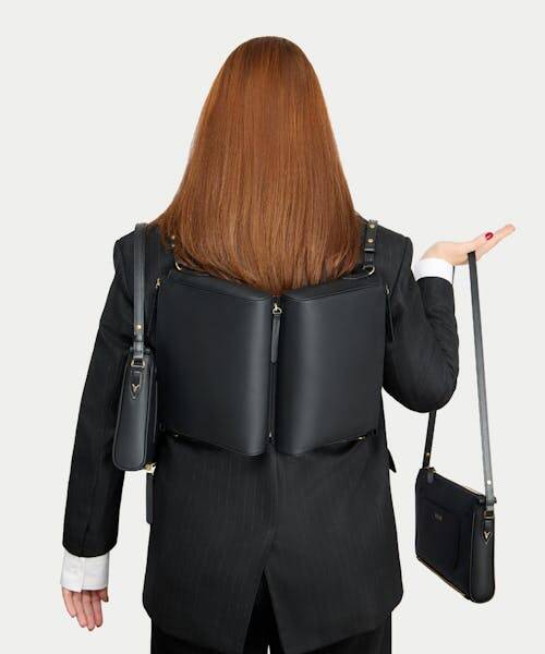 Femme, de dos, portant un sac à main noir "Paul" fabriqué en France par la marque française VOLOIR.