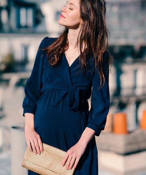 Femme enceinte portant une robe bleu fabriquées en France par la marque Neuvième Ciel.