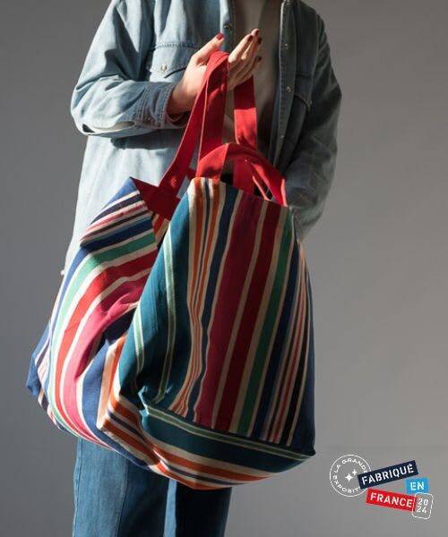 Femme portant le sac cabas Anna primé lors de la Grande Exposition du Fabriqué en France, organisée à l'Élysée.