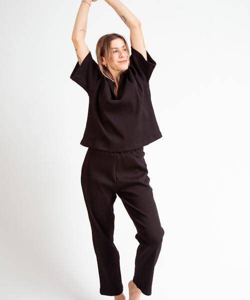 Femme portant un haut et un pantalon noirs fabriqués en France par Yomme.
