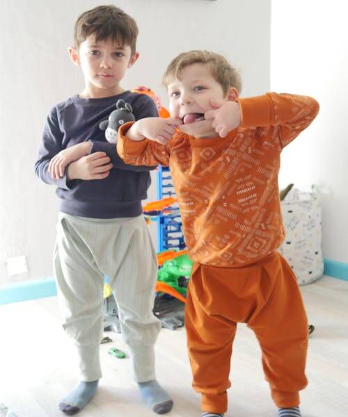 Deux garçons habillés en sweats, pantalons et sarouels fabriqués en France par Marabout, bout d’ficelle.