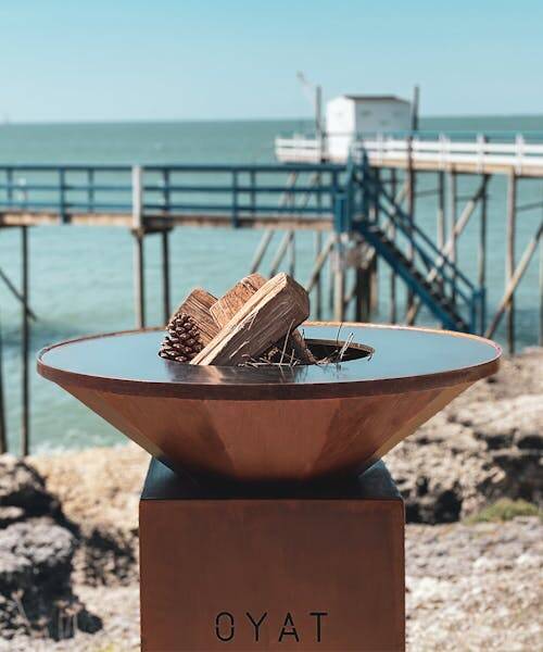 Brasero de la marque Oyat fabriqué en France et contenant des buches.