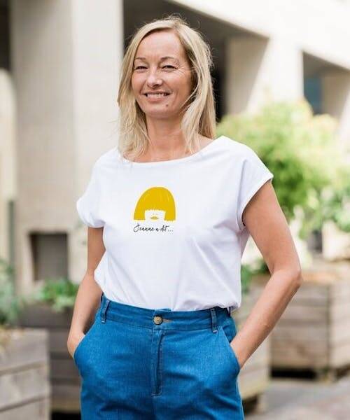 Femme blonde portant un t-shirt blanc Made in France avec imprimé en coton bio.