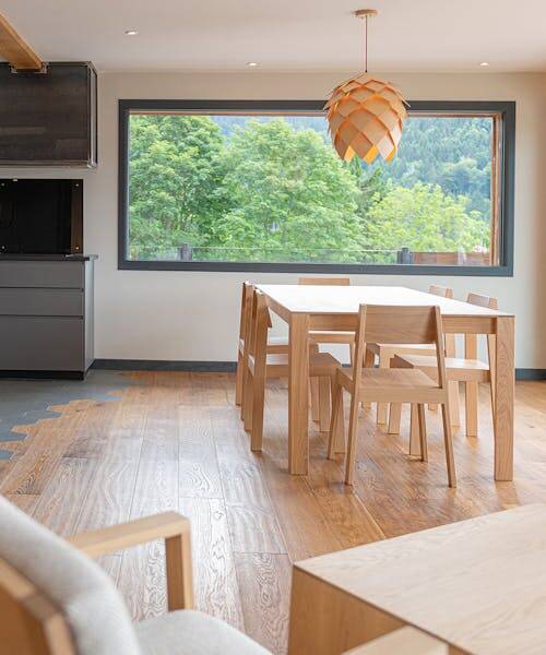 Salle à manger avec une table et six chaises en bois massif et fabriqué en France.