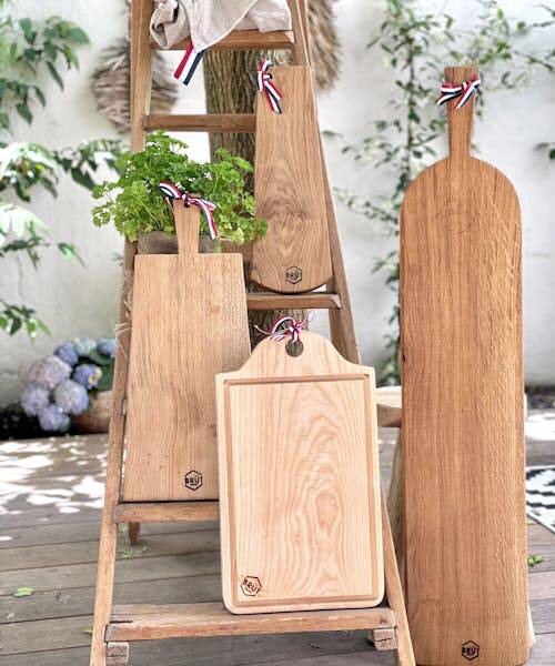 4 planches à découpé en bois massif fabriquées en France par la marque BRUT sont exposées sur une échelle. 