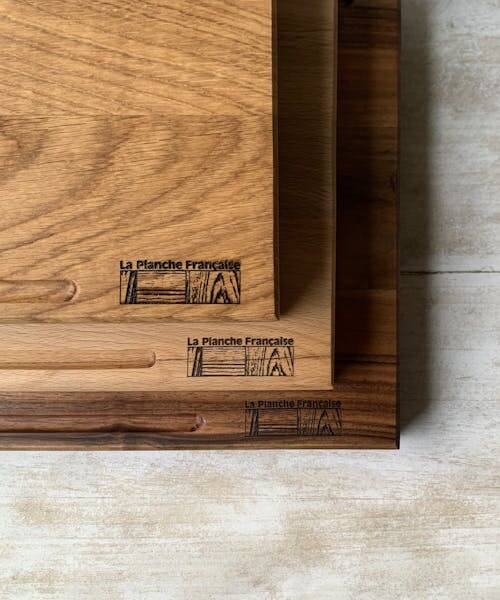 Photo de trois planche à découper en bois, superposées et fabriquées en France par la Planche Française.