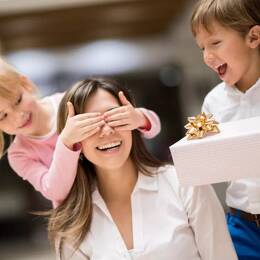 Fille blonde et garçon brun offrant un cadeau fabriqué en France pour la fête des mères à leur maman brune.
