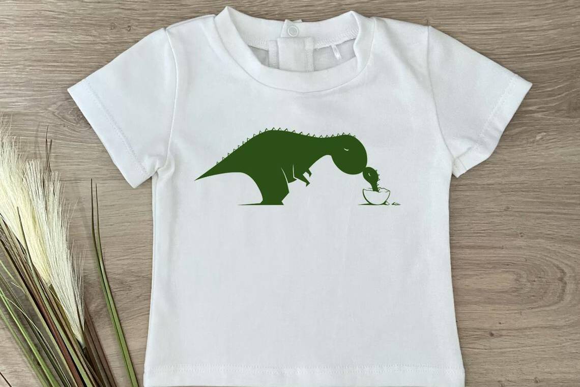 T-shirt blanc fabriqué en France avec un motif d'une maman dinosaure qui nourrie son petit.