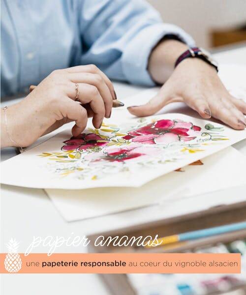 Artiste entrain de dessiner une carte de vœux fabriquées en France de la marque papierananas. 