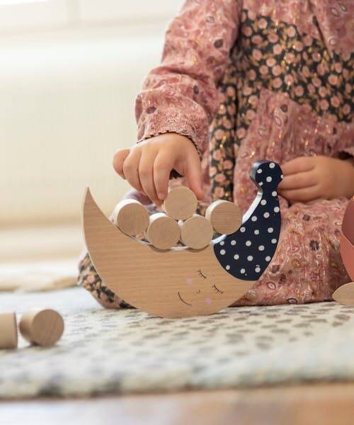 Enfant entrain de jouer à un jeux d'adresse et d'éveil en bois et fabriqué en France.