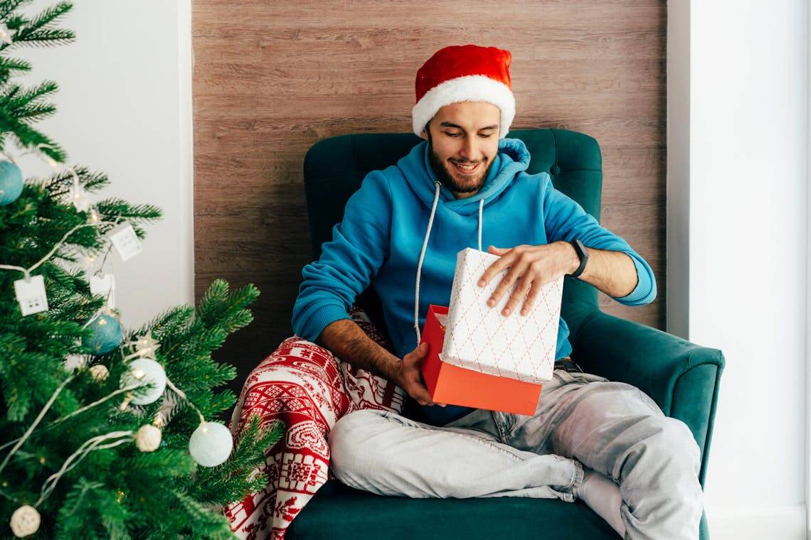 Homme déballant son cadeau de Noël fabriqué en France.