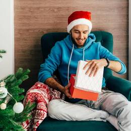 Homme déballant son cadeau de Noël fabriqué en France.