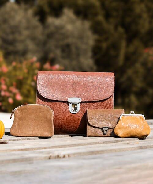 Photo d'un cartable en cuir accompagné d'une pochette et d'une porte-monnaie fabriqués en France par la cartablière.