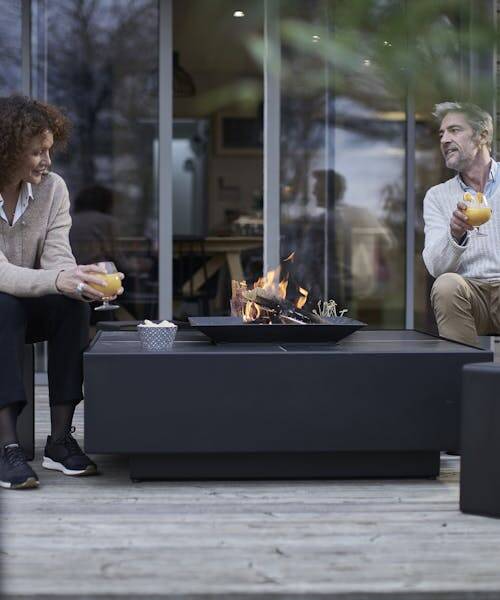 Couple assis autour d'un braséro fabriqué en France par CEMETAL.