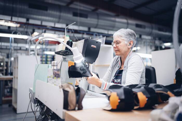 Étape de la piqûre réalisée par une ouvrière dans l'atelier de fabrication française La Manufacture 49.