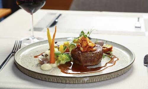 Assiette d'un restaurant gastronomique accompagné d'un verre de vin français.