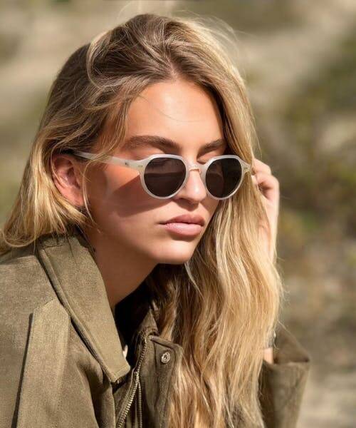 Femme portant des lunettes solaires fabriquées en France par eio.