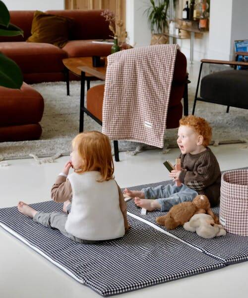 Deux enfants en train de jouer sur un tapis de vie fabriqué en France par Mezamé Paris