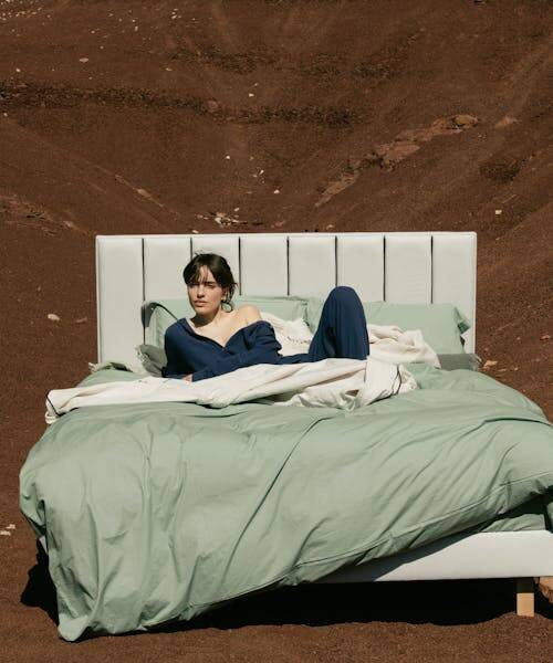 Femme dormant un lit en extérieur avec un matelat fabriqué en France par Dormez Français.