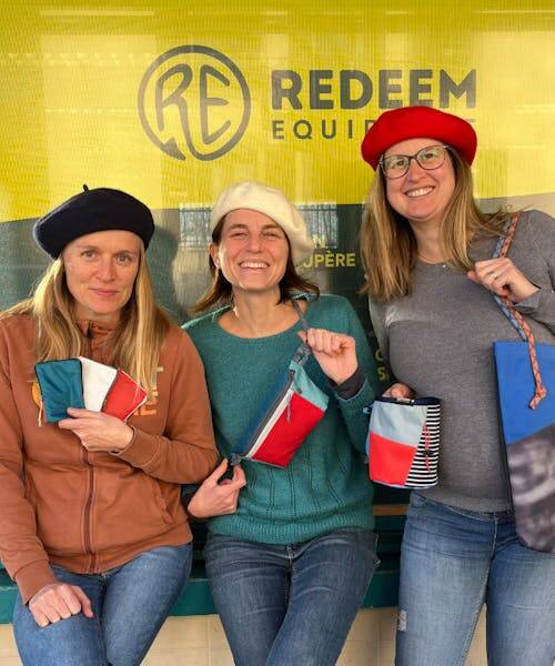L'équipe  REDEEM EQUIPMENT portant de berrets bleu blanc rouge avec leurs accesoires upcyclés : banane, sac et porte-monnaie.