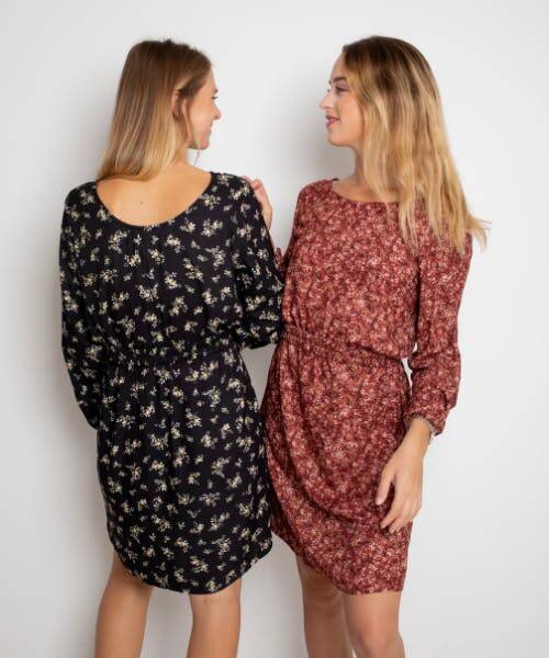 Deux femmes portants des blouses fleuries de couleur noir et bordeau. Ces robes sont fabriqués en France par la marque April & C.