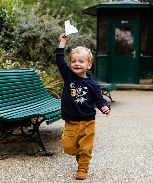 Petit garçon blond portant un magnifique sweat bleu Made in France avec motif aventurier.