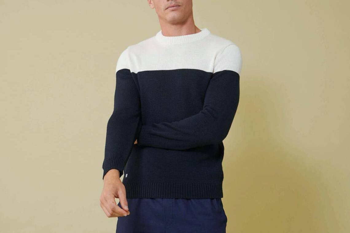 Homme brun portant un pull Tilio blanc et marine fabriqué en France par Le Slip Français.
