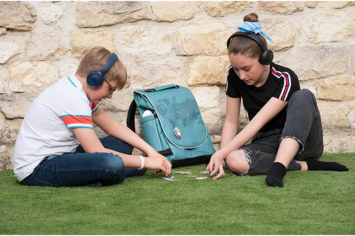 Enfants en train de jouer devant sac à dos made in France avant la rentrée.